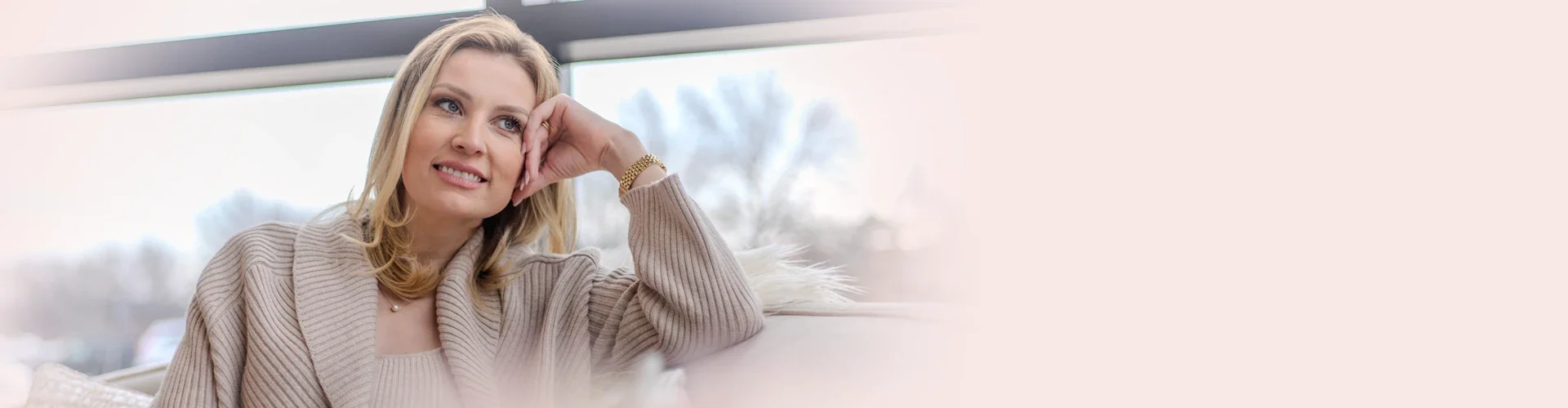 Fran Kroll smiling, resting her hand on her chin in a beige knit sweater