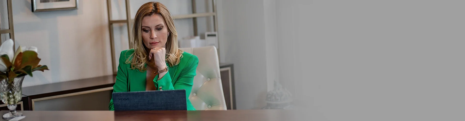 Fran Kroll in a green blazer working on a laptop at her desk